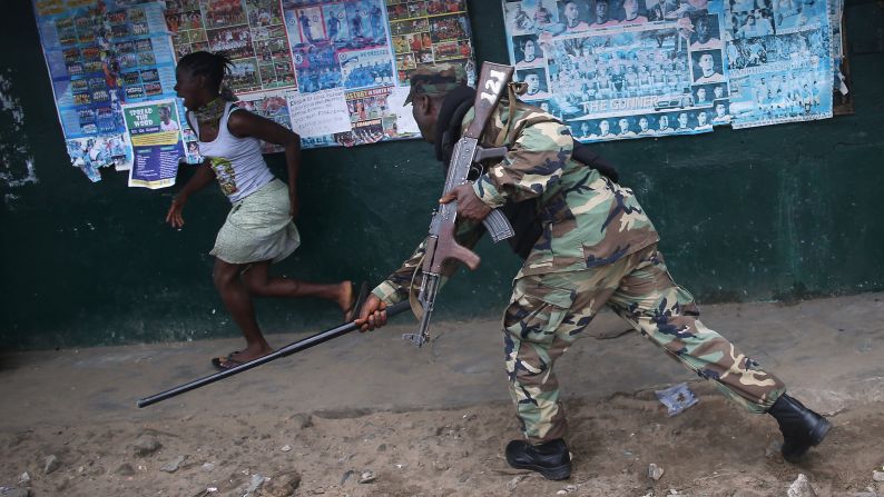 An Ebola Task Force soldier beats a local resident while enforcing a quarantine in the West Point slum of Monrovia, Liberia, on Wednesday, August 20. The Ebola virus has killed more than 1,350 people in West Africa since March, according to the World Health Organization. 