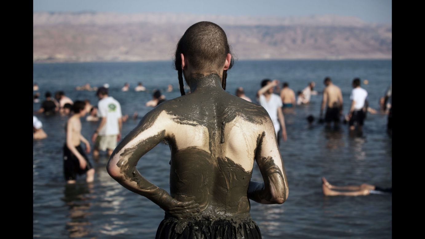 Ultra-Orthodox Jewish men and boys cover their bodies with mineral-rich mud on the shores of the Dead Sea during their vacation Sunday, August 17, at a beach in the West Bank.