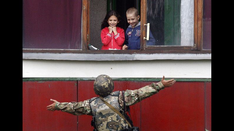 A Ukrainian soldier gestures as he talks with children Monday, August 18, in Popasna, a Ukrainian city recently held by pro-Russian rebels. 