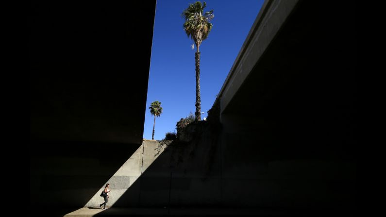 A woman walks under the 101 Freeway in Los Angeles on Friday, August 15.
