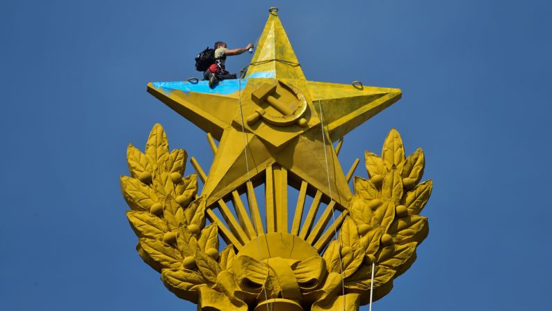 A worker repaints the top of a Stalin-era skyscraper in Moscow on Wednesday, August 20. The giant star had been painted in yellow and blue, Ukraine's national colors, by unknown people. A Ukrainian flag was also hung from the star.