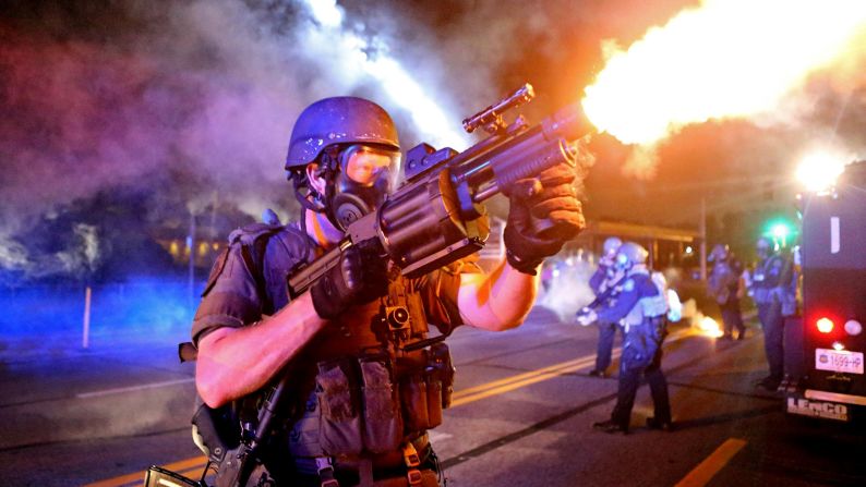 A law enforcement officer fires tear gas in the direction where bottles were thrown from crowds Monday, August 18, in Ferguson, Missouri. The St. Louis suburb <a href="http://www.cnn.com/2014/08/14/us/gallery/ferguson-missouri-protests/index.html">has been in turmoil</a> since Darren Wilson, a white police officer, fatally shot Michael Brown, an unarmed black teenager, on August 9. Some protesters and law enforcement officers have clashed in the streets, leading to injuries and arrests.