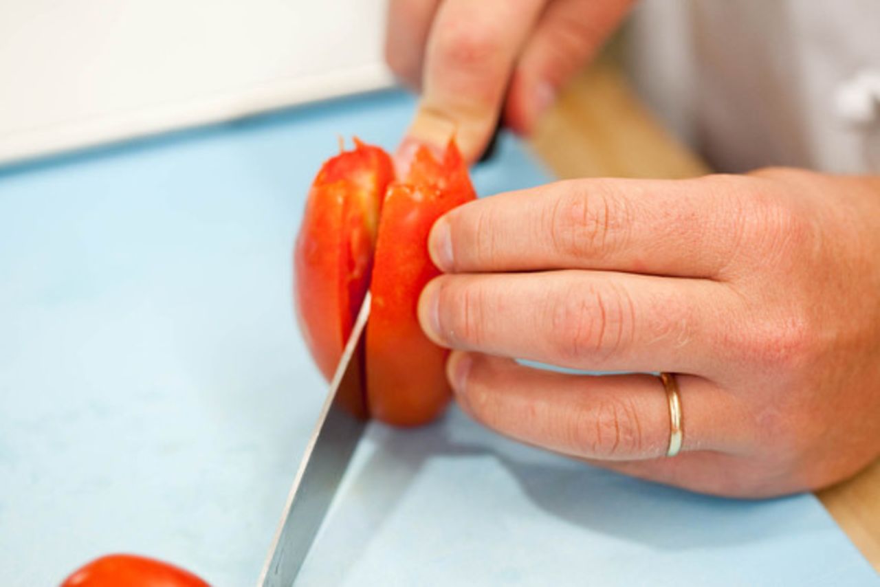 Once the tomatoes are cored, halve them through the core with a chef's or serrated knife. Don't remove the seeds or jelly-like pulp, though, because they both contain a lot of flavor.