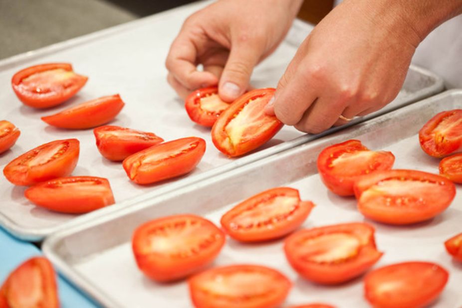 Slow-roast the tomatoes on rimmed baking sheets, which will contain any runaway liquid; for easy cleanup, line the baking sheets with parchment paper or aluminum foil. Distribute half of the tomatoes (cut-side up) on each sheet.