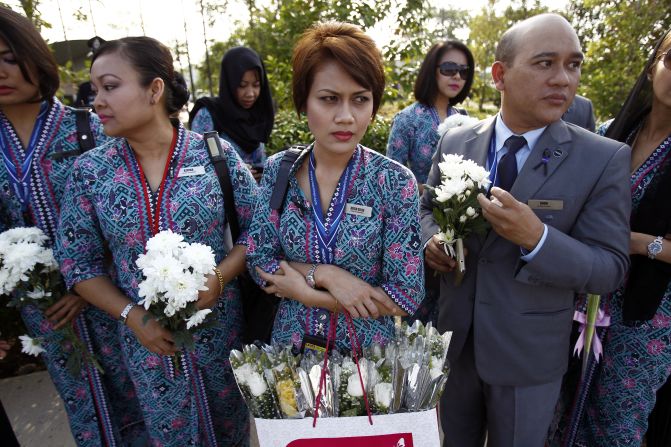Malaysia Airlines' crew members held flowers as they waited for the plane's arrival. MH17 was shot down over eastern Ukraine on July 22, killing all 298 people on board.