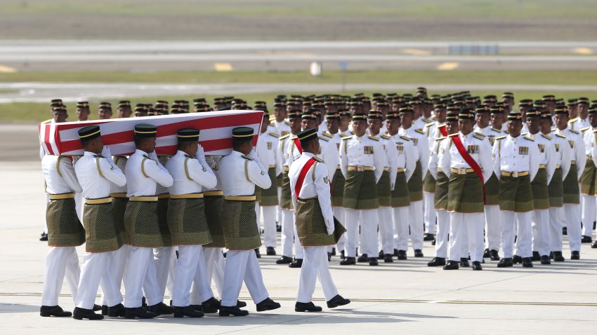 Malaysia Army soldiers carry one of the bodies of the downed MH17 flight on the arrival at Kuala Lumpur International Airport in Sepang, Malaysia, Friday, Aug. 22, 2014. The bodies of 20 victims' of the ill-fated Malaysia Airlines flight that was shot down over eastern Ukraine last month, returned home from Amsterdam on Friday. (AP Photo/Vincent Thian)