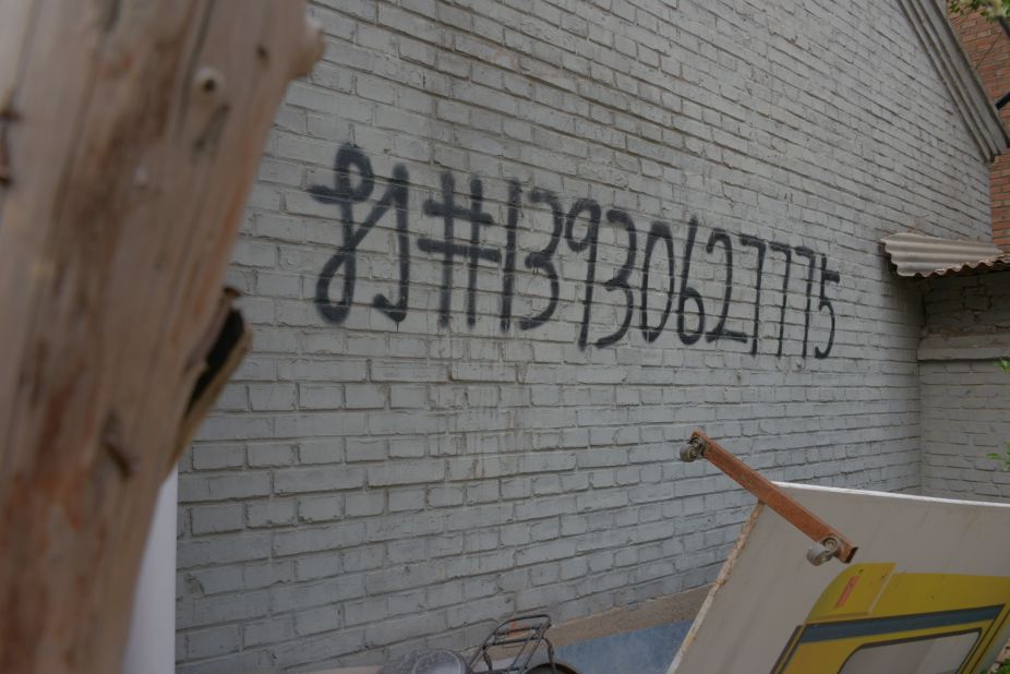 Graffiti on a wall, advertising well-digging services. A well can cost up to $6,500, according to residents.