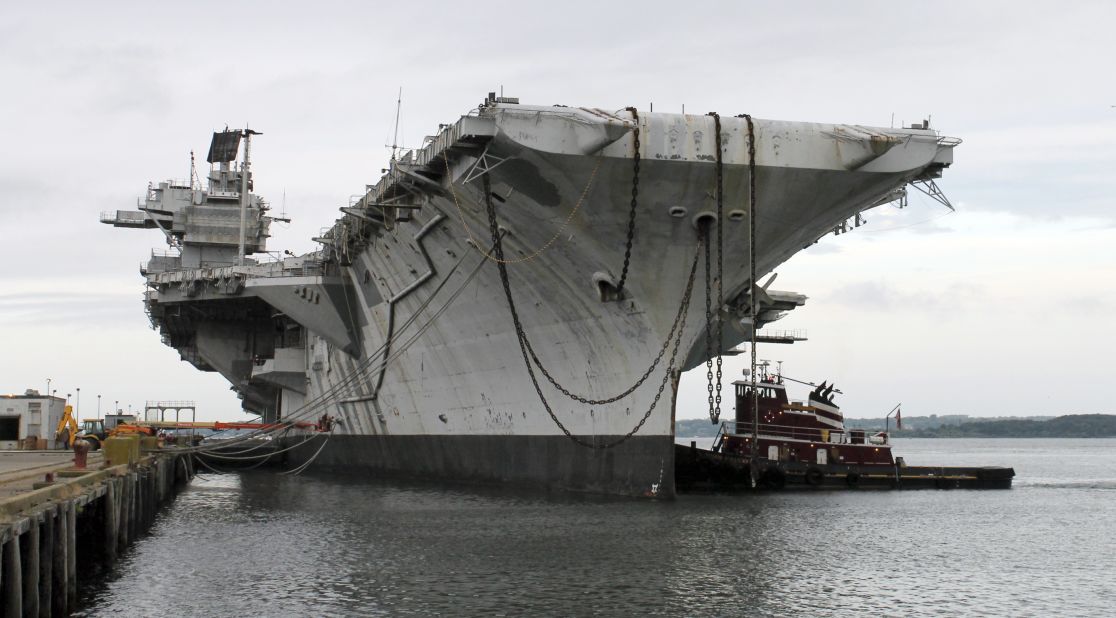 In this photo released by the U.S. Navy, a tugboat works alongside the decommissioned aircraft carrier USS Saratoga on Thursday, August 21, in Newport, Rhode Island. The Navy has paid a Texas recycling company a penny to dispose of the Saratoga, part of the Forrestal-class of "supercarrier" vessels built for the Atomic Age. The carrier was decommissioned 20 years ago.