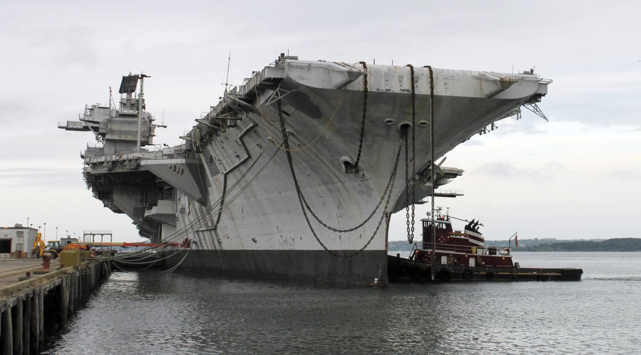 In this photo released by the U.S. Navy, a tugboat works alongside the decommissioned aircraft carrier USS Saratoga on Thursday, August 21, in Newport, Rhode Island. The Navy has paid a Texas recycling company a penny to dispose of the Saratoga, part of the Forrestal-class of "supercarrier" vessels built for the Atomic Age. The carrier was decommissioned 20 years ago.