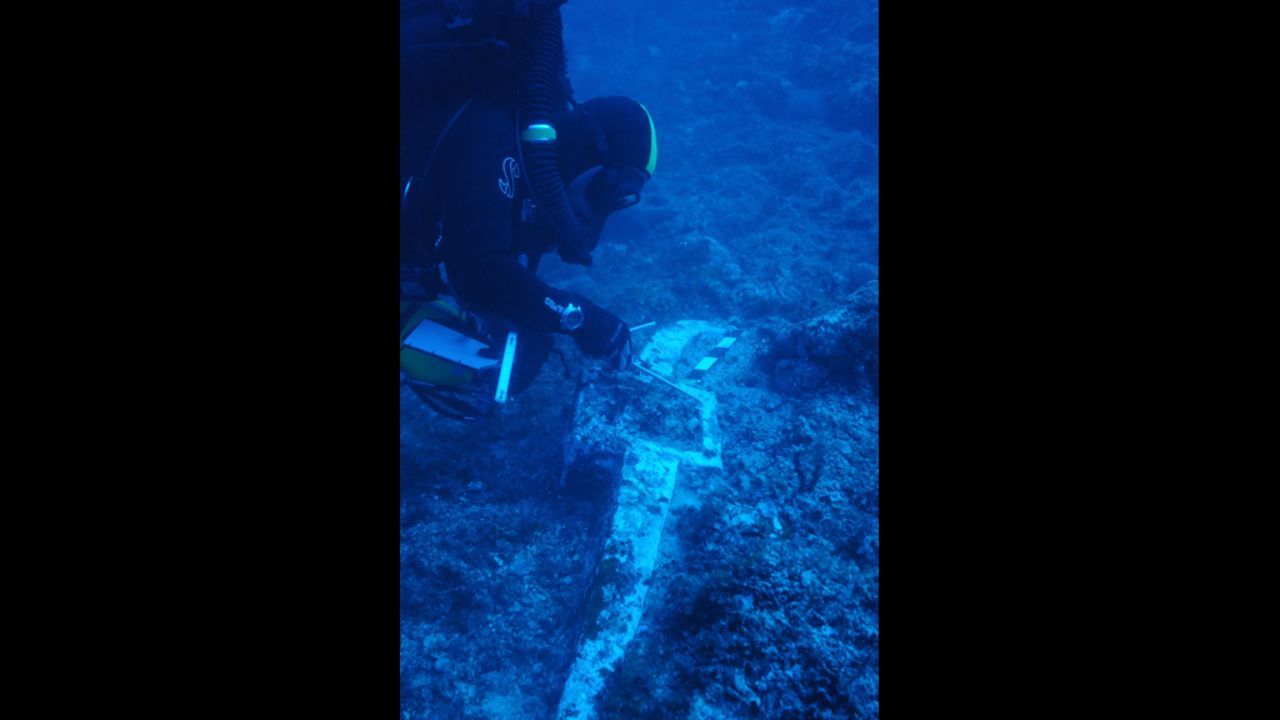 Greek archaeologist and fellow co-director of the dive, Theotokis Theodoulou inspects the 400-pound lead anchor stock of Antikythera Wreck B, found last year at one end of the debris field during a preparatory dive. The other end of the wreck is signaled over 50 meters away by roof tiles believed to be from the galley structure at the stern of the ship. Based on this evidence, scientists estimate the vessel to be one of the largest ships from antiquity, making it bigger than some of the most colossal boats known from that time -- Caligula's pleasure barges on Italy's Lake Nemi. 