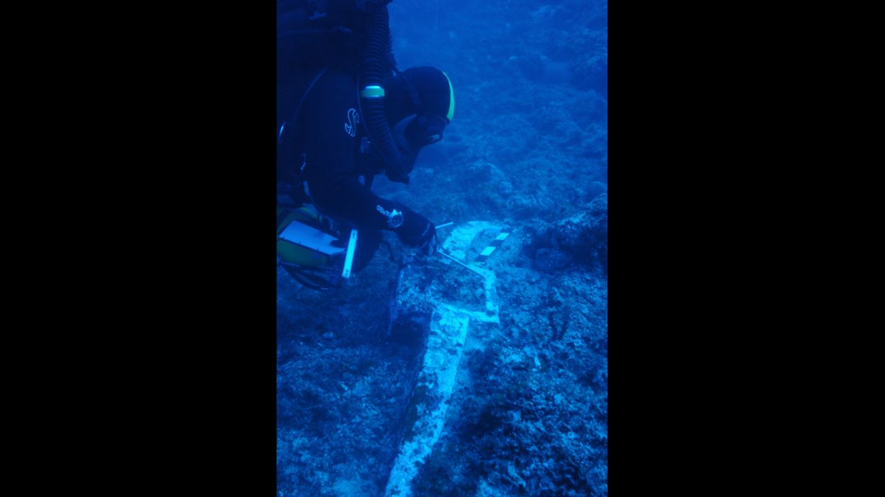 Greek archaeologist and fellow co-director of the dive, Theotokis Theodoulou inspects the 400-pound lead anchor stock of Antikythera Wreck B, found last year at one end of the debris field during a preparatory dive. The other end of the wreck is signaled over 50 meters away by roof tiles believed to be from the galley structure at the stern of the ship. Based on this evidence, scientists estimate the vessel to be one of the largest ships from antiquity, making it bigger than some of the most colossal boats known from that time -- Caligula's pleasure barges on Italy's Lake Nemi.