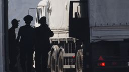 A driver, left, and Russian custom service officers stand near trucks of the Russian aid convoy which are searched at a Russian inspection zone inside a border control point with Ukraine in the Russian town of Donetsk, Rostov-on-Don region, Russia, Friday, Aug. 22, 2014. The first trucks of the Russian aid convoy crossed the Ukrainian inspection zone Friday morning. (AP Photo/A driver, left, and Russian custom service officers stand near trucks of the Russian aid convoy which are searched at a Russian inspection zone inside a border control point with Ukraine in the Russian town of Donetsk, Rostov-on-Don region, Russia, Friday, Aug. 22, 2014. The first trucks of the Russian aid convoy crossed the Ukrainian inspection zone Friday morning. (AP Photo/Pavel Golovkin))