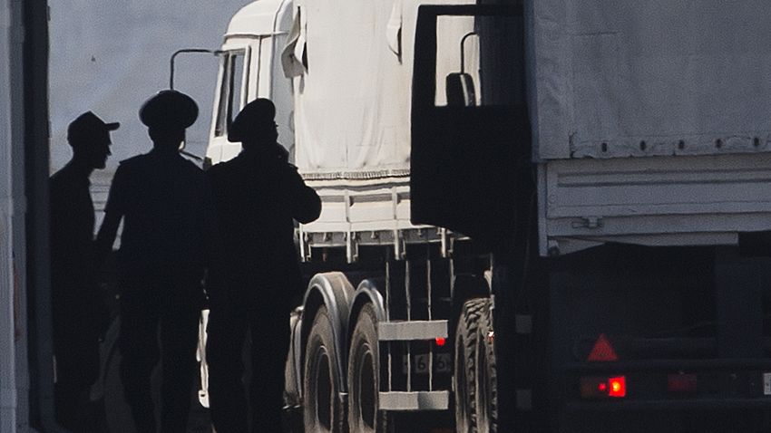 A driver, left, and Russian custom service officers stand near trucks of the Russian aid convoy which are searched at a Russian inspection zone inside a border control point with Ukraine in the Russian town of Donetsk, Rostov-on-Don region, Russia, Friday, Aug. 22, 2014. The first trucks of the Russian aid convoy crossed the Ukrainian inspection zone Friday morning. (AP Photo/A driver, left, and Russian custom service officers stand near trucks of the Russian aid convoy which are searched at a Russian inspection zone inside a border control point with Ukraine in the Russian town of Donetsk, Rostov-on-Don region, Russia, Friday, Aug. 22, 2014. The first trucks of the Russian aid convoy crossed the Ukrainian inspection zone Friday morning. (AP Photo/Pavel Golovkin))