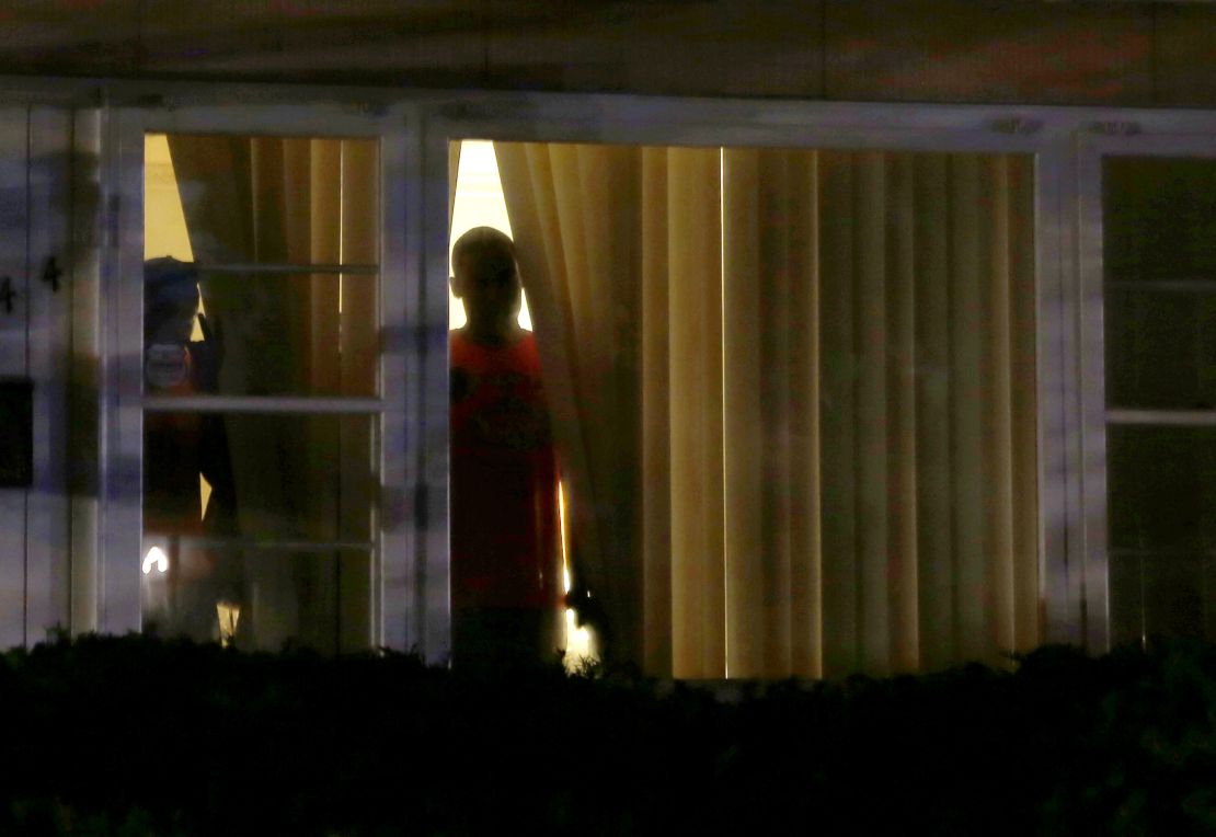 People look out the windows of a house as police wearing riot gear try to disperse a crowd in Ferguson, Missouri, on August 11, days after the shooting death of Michael Brown.