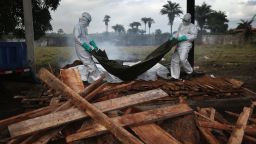 A burial team from the Liberian Ministry of Health unloads the bodies of Ebola victims onto a funeral pyre at a crematorium on August 22 in Marshall, Liberia.