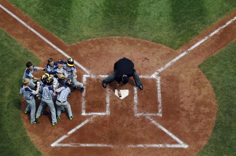 Australia's Javier Pelkonen, center of pile, is mobbed by teammates after hitting a home run during the fourth inning against the Czech Republic on Saturday, August 16.