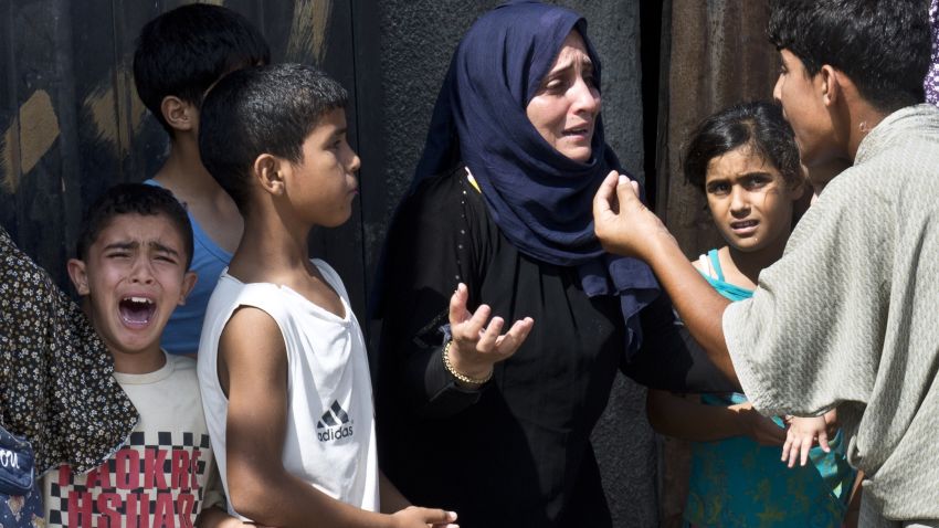 A Palestinian boy cries in panic as other members of his family discuss what to do after they ran out of their house in a hurry on August 23, 2014 in Gaza City.