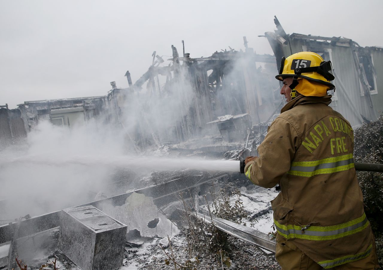 A Napa County firefighter sprays foam on hot spots from a fire at a mobile home park in Napa on August 24. 