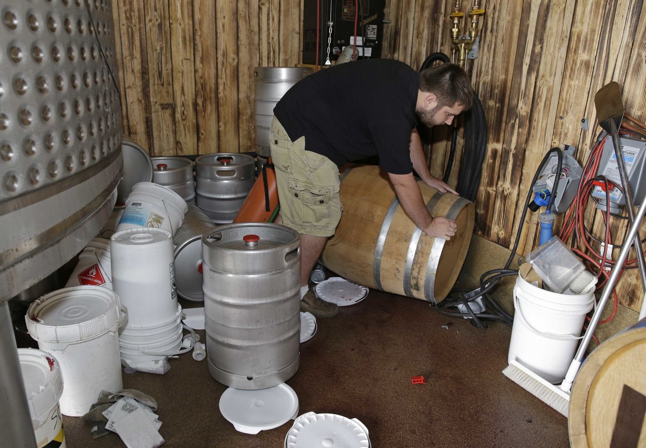 Tyler Dahl looks over a $16,000 barrel of Pinot Noir wine that fell from a rack and broke open after the earthquake at Dahl Vineyards on August 24 in  Yountville, California. 