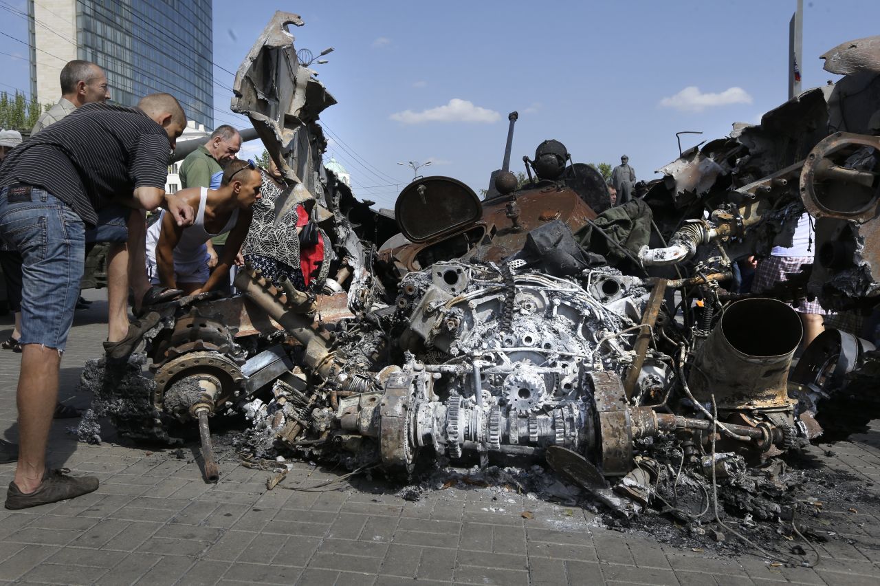 People look at damaged Ukrainian military equipment in Donetsk on August 24. 