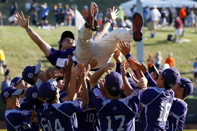 South Korean players hold coach Sang Hoon-hwang after winning the championship baseball game against Chicago at the Little League World Series in South Williamsport, Pennsylvania, on Sunday, August 24. South Korea won 8-4.