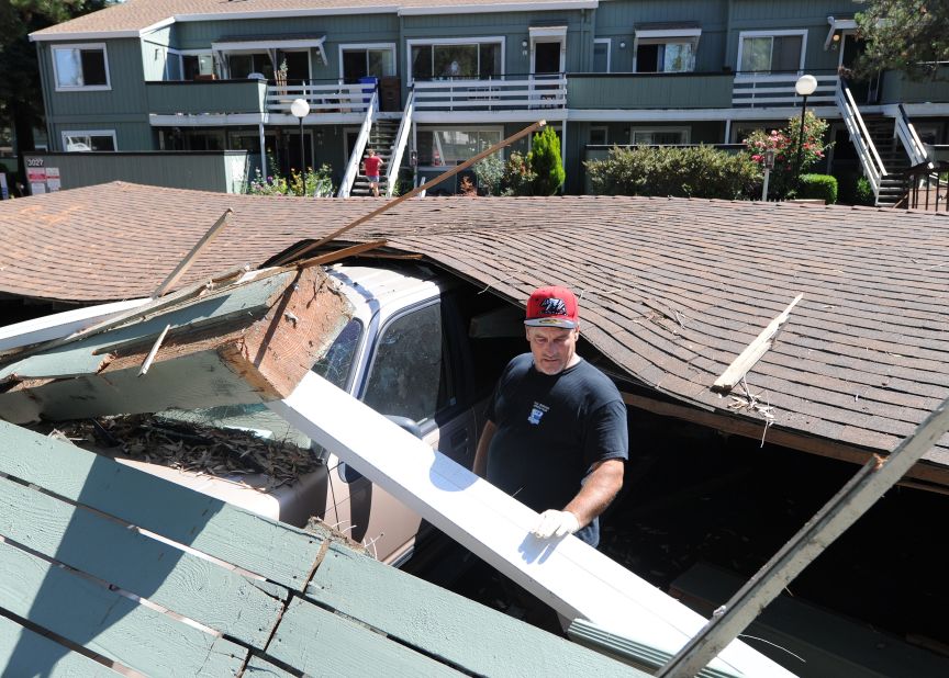 Karl Luchsinger attempts to disentangle his daughter's car on August 24 after the car port it was parked in collapsed in Napa.