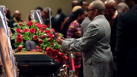Filmmaker Spike Lee takes a picture of a St. Louis Cardinals baseball cap that rests on top of Brown's casket.
