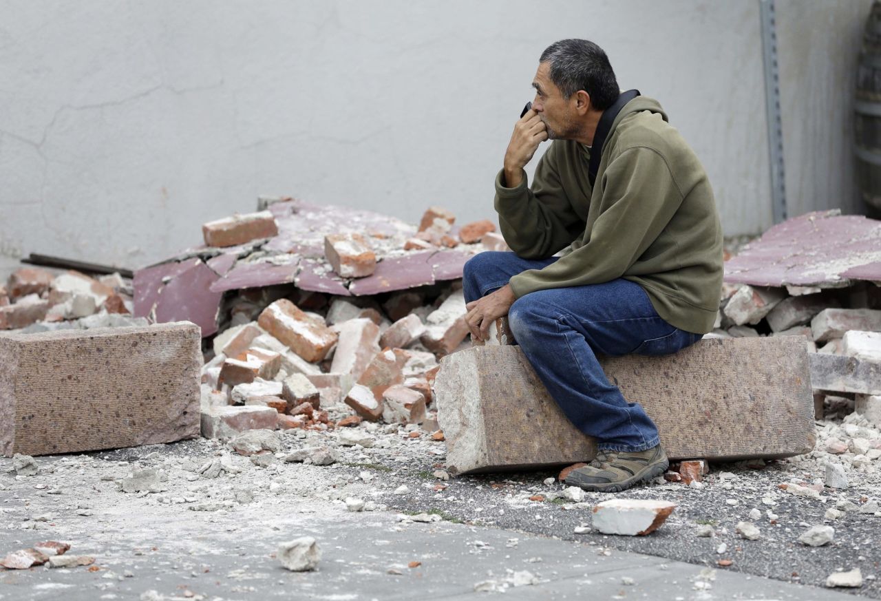 Ron Peralez sits on rubble and looks at damaged buildings on Monday, August 25, in Napa, California. The San Francisco Bay Area's strongest earthquake in 25 years struck the heart of California's wine country on August 24.