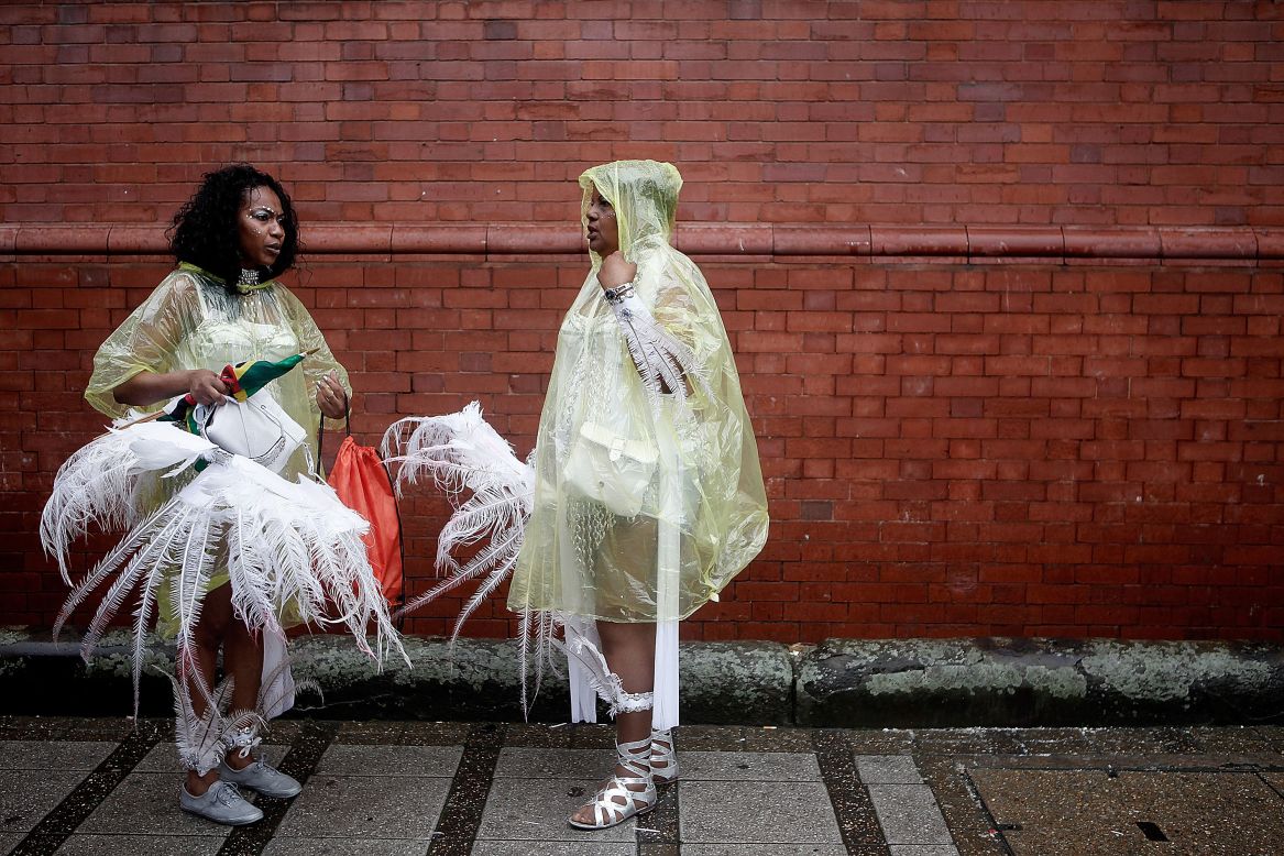  AUGUST 26 - LONDON, ENGLAND: Performers in ponchos protect their delicate costumes during the rain soaked Notting Hill Carnival. Over a million visitors attended the two-day event despite the bad weather. The carnival, first organized in 1964, has grown into the largest in Europe.