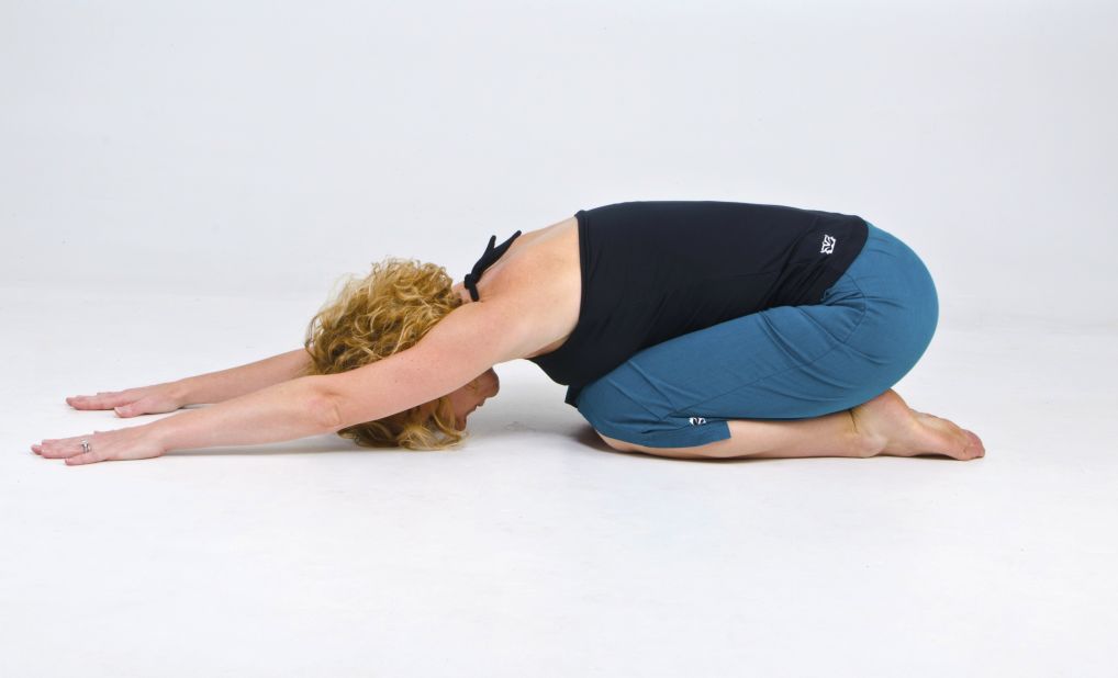 Extended child's pose stretches low-back extensors and encourages proper pelvic alignment.