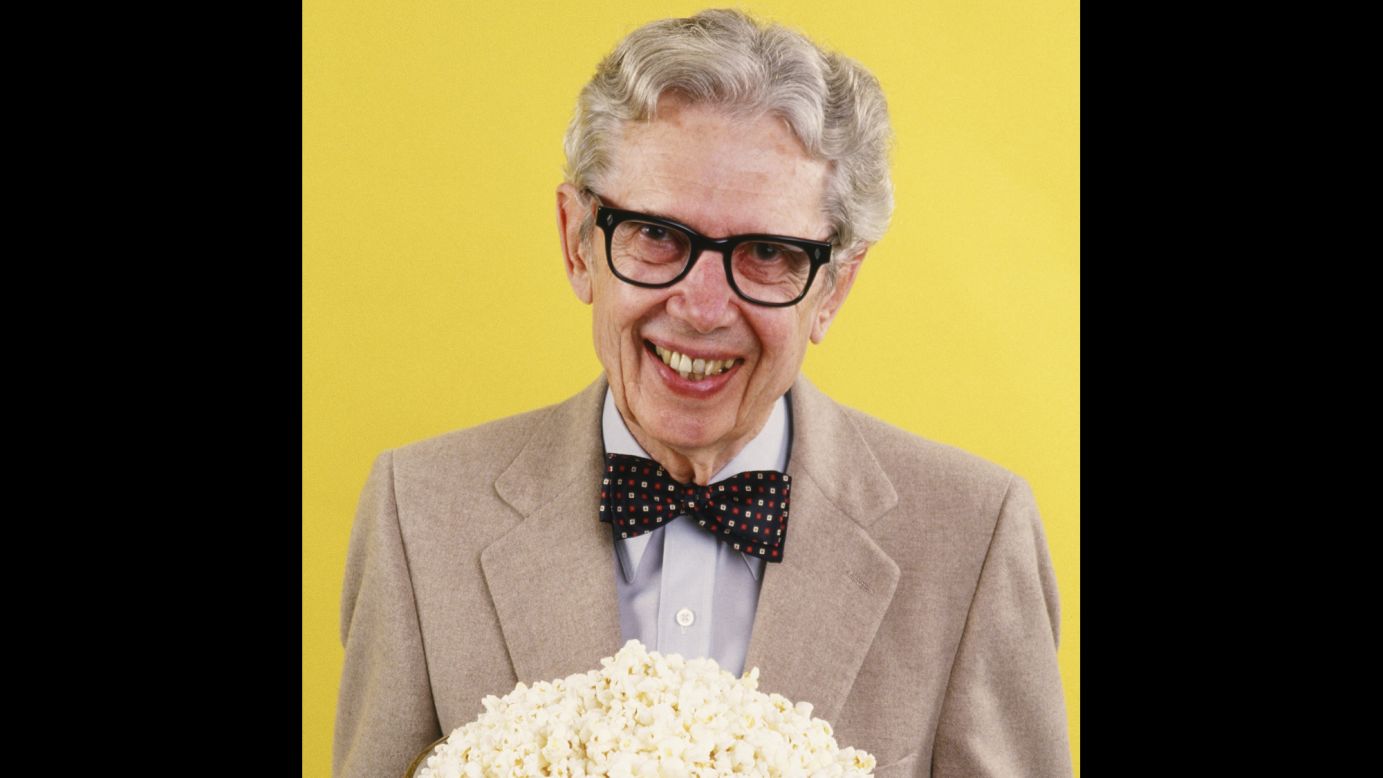 Popcorn king Orville Redenbacher playfully poses with a big bowl of popcorn in 1986. His bow-tied, bespectacled image graces packages of his product.