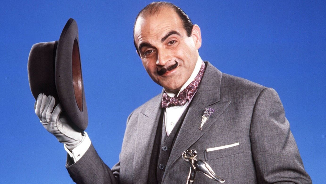 David Suchet plays the French detective Hercule Poirot, originally created by author Agatha Christie, in television's "Poirot." His fancy accessories typically include a hat, bow tie and pince-nez eyeglasses. A pointy handlebar mustache finishes the look.