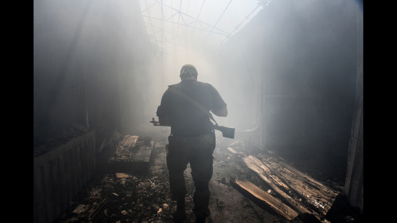 A pro-Russian rebel walks through a local market damaged by shelling in Donetsk on Tuesday, August 26.