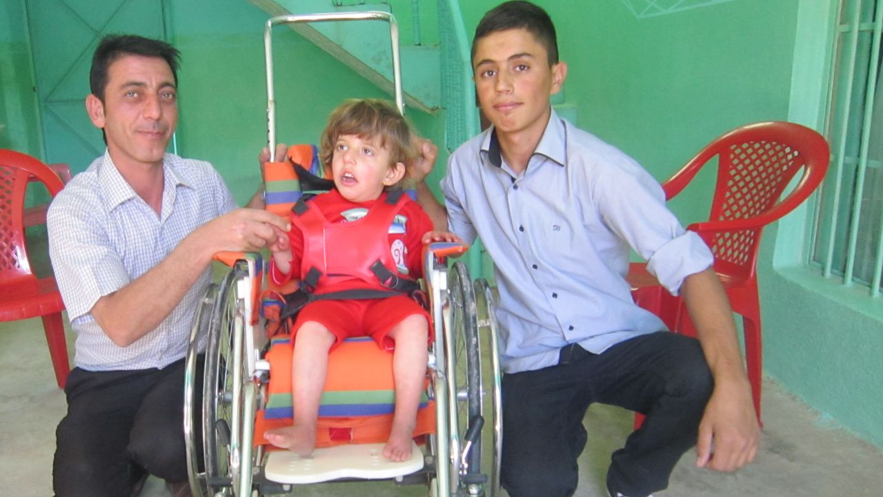 Azwan, right, used to help deliver wheelchairs for disabled Iraqi kids.