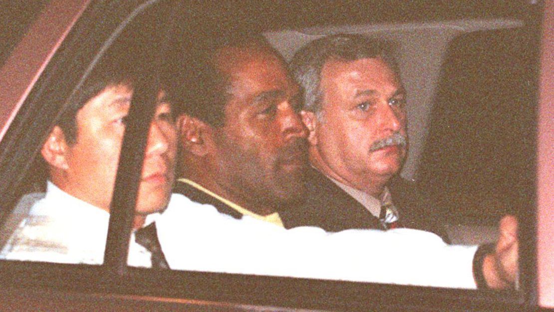 O.J. Simpson, accompanied by two Los Angeles police detectives, is driven away after his arrest.