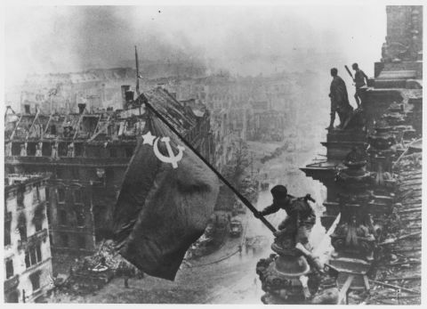 Russian soldiers wave their flag, made from tablecloths, over the ruins of the Reichstag in Berlin on April 30, 1945. That day, as the Soviets were within blocks of his bunker at the Reich Chancellery, Adolf Hitler committed suicide. 