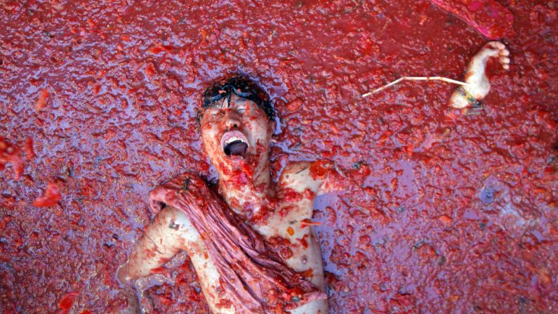 A man lies in a puddle of squashed tomatoes during a tomato fight in the village of Bunol, Spain, on Wednesday, August 27. The annual Tomatina festival has become a major tourist attraction.