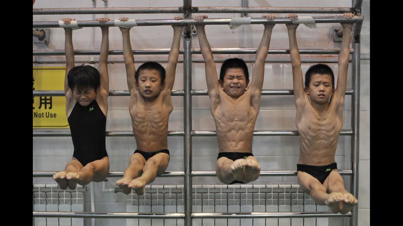 Young divers stretch while training at a sports school in Hefei, China, on Saturday, August 23.