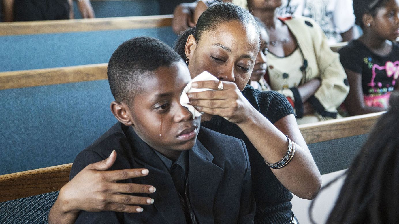 Sharon Lamb wipes tears from her 10-year-old son Kasai Hayden's face during the funeral for Michelle Cusseaux in Phoenix, Arizona, on Saturday, August 23. Cusseaux, 50, was shot earlier this month after she threatened officers with a claw hammer, authorities said. They were at her apartment to carry out an emergency court order to take her to a mental health facility.