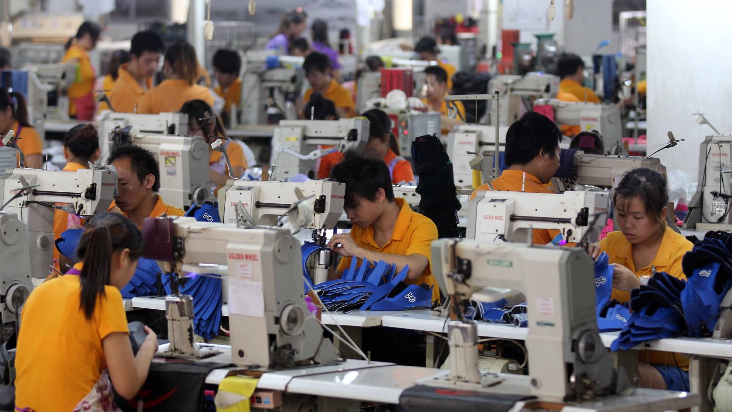 All in a day's work: Laborers sew away in a typical shoe factory in southern China's Fujian province.