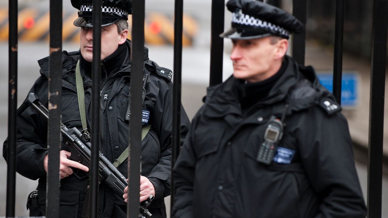 Armed policemen stand guard at the gates of Downing Street in London.