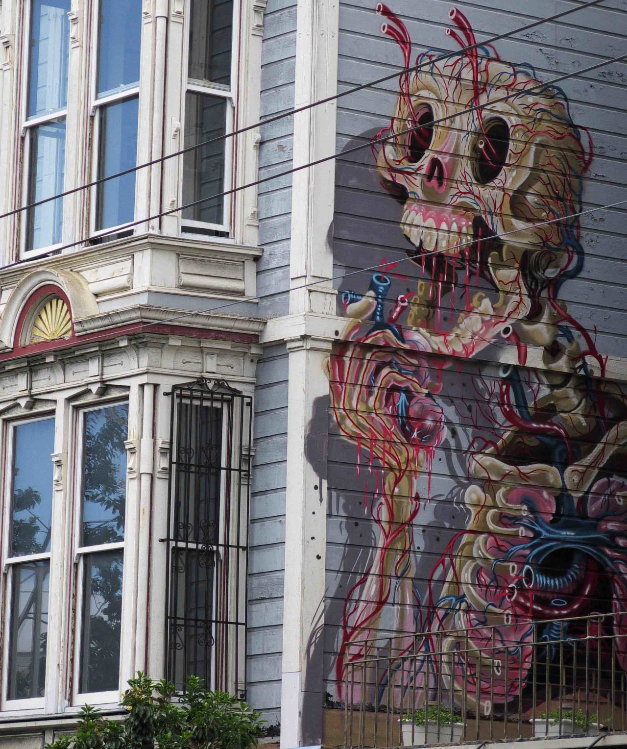 A professional mural illustrates the side of an antique house in San Francisco's Haight-Ashbury neighborhood.