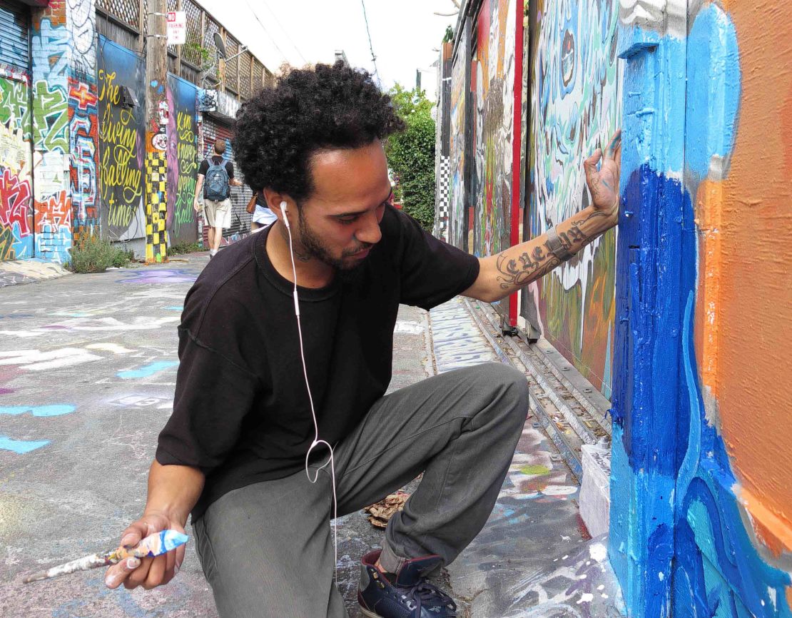 Artist Carlos Daniel Perez-Boza works on an authorized mural in the Mission District.