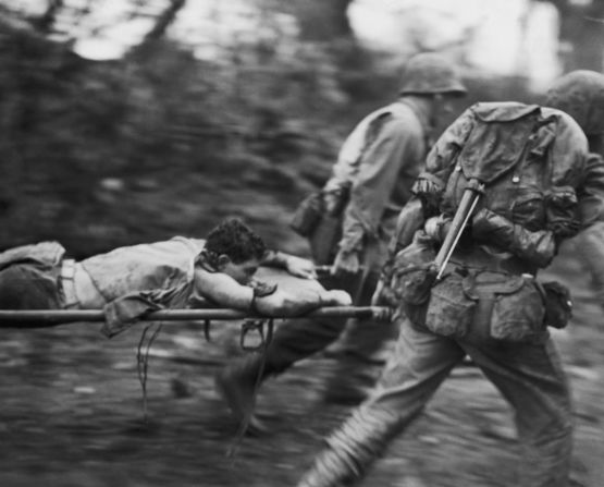 Soldiers rush an injured U.S. Marine from a battlefield during the Battle of Okinawa in June 1945. The battle, the bloodiest of the war in the Pacific, raged for nearly three months and heightened U.S. concerns for the enormous casualties that could be anticipated in the planned invasion of Japan's main islands.