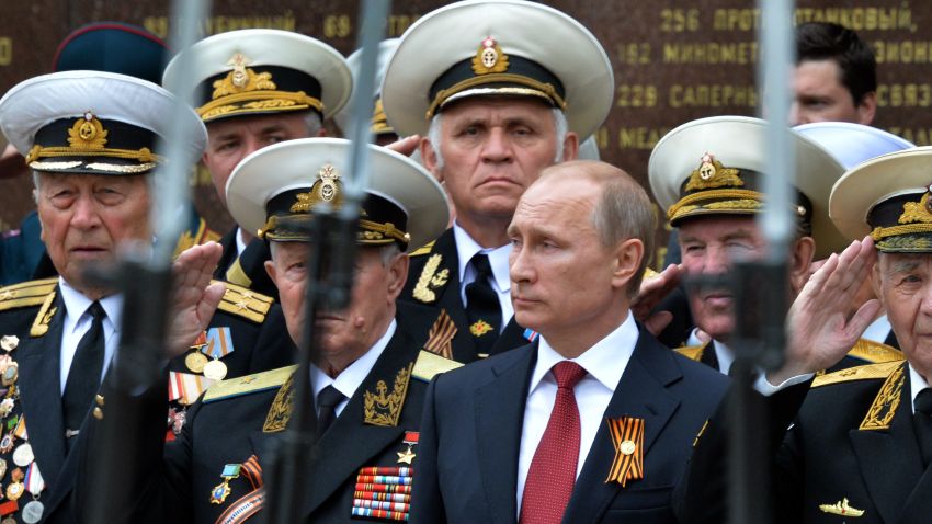 Caption:Russia's President Vladimir Putin (C) and World War II veterans watch a parade of honour guard during his visit to the Crimean port of Sevastopol on May 9, 2014. Putin's visit to Crimea, which was annexed by Moscow in March, is a 'flagrant violation' of Ukraine's sovereignty, authorities in Kiev said today. AFP PHOTO/ YURI KADOBNOV (Photo credit should read YURI KADOBNOV/AFP/Getty Images)