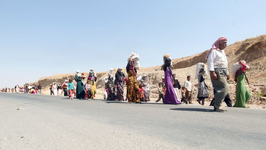 Displaced Iraqi families from the Yazidi community cross the Iraqi-Syrian border at the Fishkhabur crossing to safety, in northern Iraq, on August 13, 2014. 