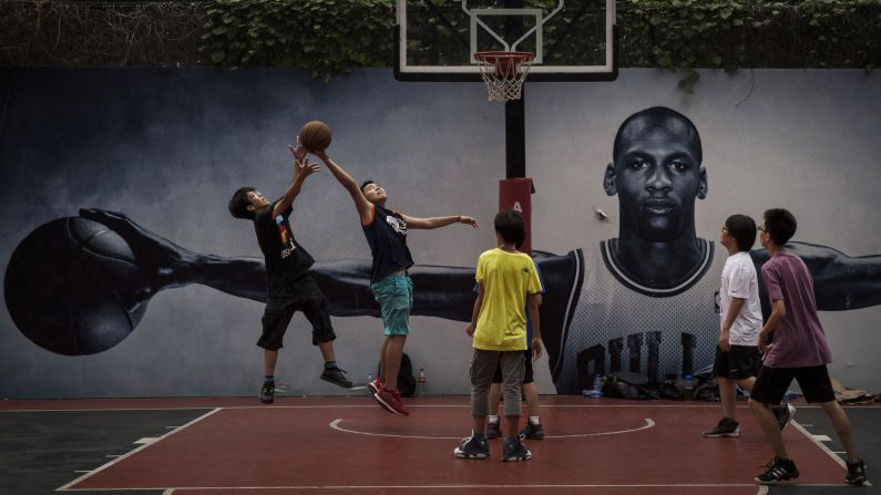 Students in Beijing play basketball on a court that has a poster of NBA great Michael Jordan on Monday, September 1. Basketball is one of the fastest-growing youth sports in China.