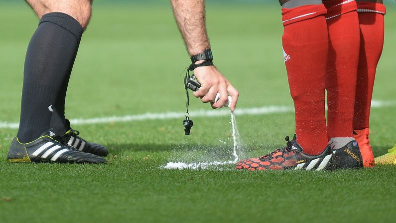 Referee Paul Tierney uses vanishing spray to mark the 10-yard line for a free kick Saturday, August 30, during a Premier League match between Swansea City and West Bromwich Albion in Swansea, Wales. The spray is being used in the league <a href="http://www.cnn.com/2014/07/31/sport/football/football-vanishing-spray-english-premier-league/index.html">for the first time</a> this season.