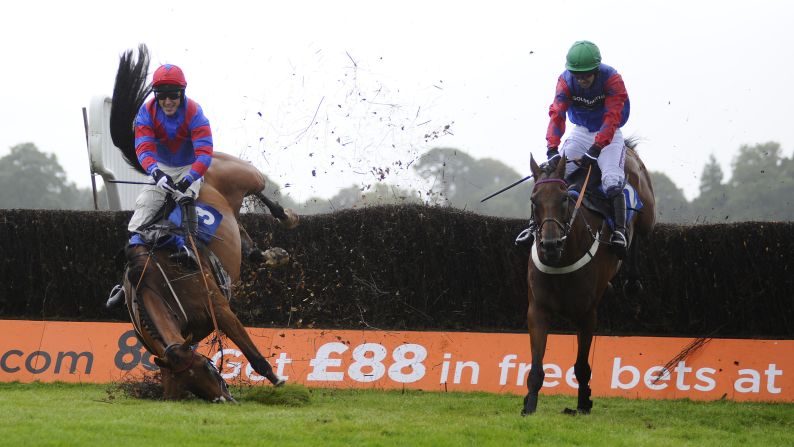 Tony McCoy, riding Rendl Beach, falls during a steeplechase race Thursday, August 28, at the Fontwell Park Racecourse in Fontwell, England. The 32Red Beginners' Chase was won by Will Kennedy, right, aboard Leath Acra Mor.