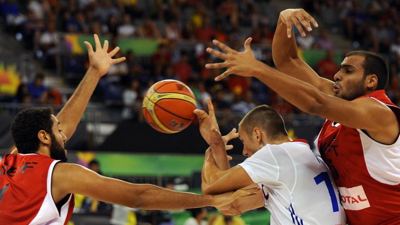 Egyptian forwards Seif Samir, left, and Amr Gendy, right, defend France's Kim Tillie during a FIBA World Cup game Monday, September 1.